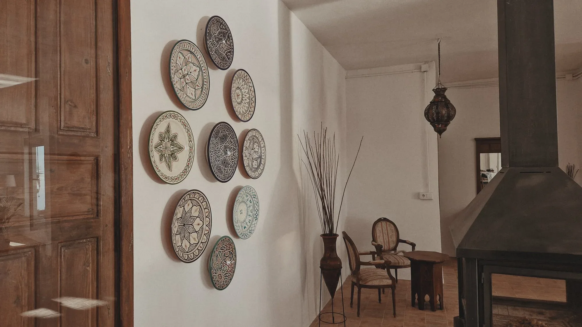 The living room, with its wall of Andalusian ceramics and a small table by the fire